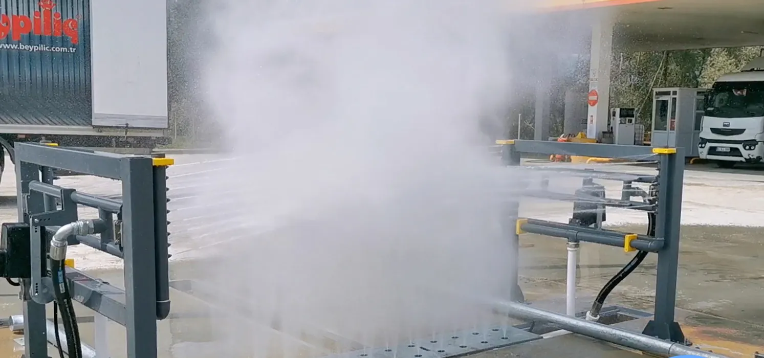 Chassis spray jets washing across an underbody wash bay